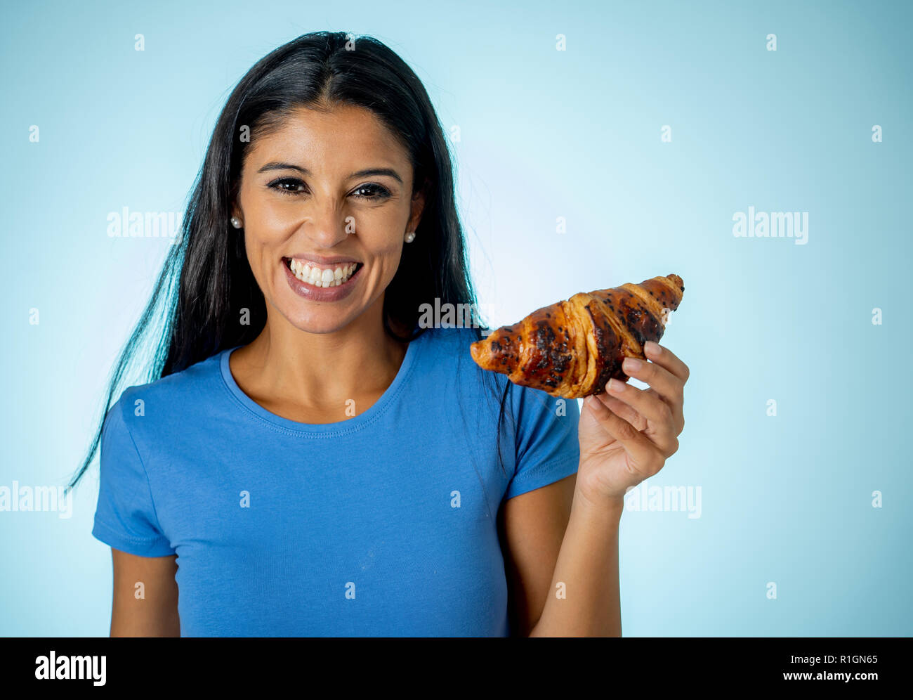 Belle jeune femme latine mignon et heureux dans les tenues de holding big délicieux pain au chocolat à la tentation de penser si ignorant di Banque D'Images