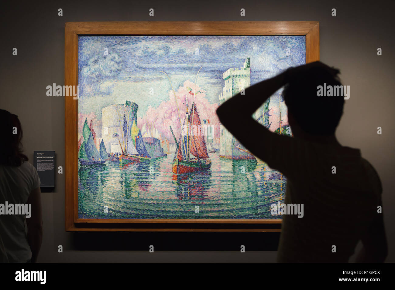 Visiteur en face de la peinture 'entrée du port de La Rochelle (''entrée du port de la Rochelle") par des néo-impressionnistes français peintre Paul Signac (1921) affiché dans le Musée d'Orsay à Paris, France. Banque D'Images