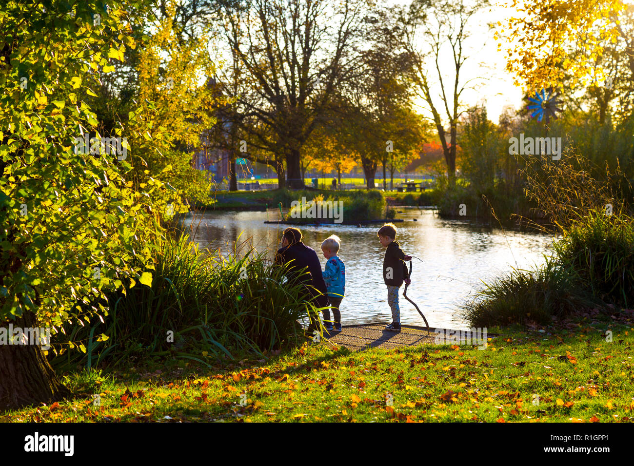 Enfants et père jouant à Victoria Park en automne, Londres, Royaume-Uni Banque D'Images