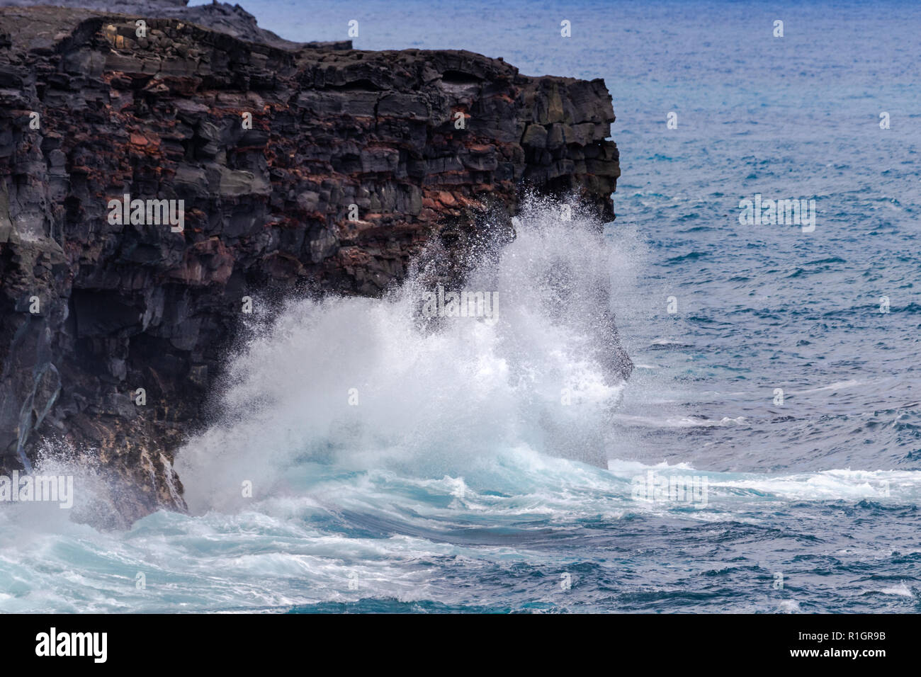 De grosses vagues se briser contre les falaises volcaniques hautes sur Hawaii's Big Island, au-dessous de la route de la chaîne des cratères dans Volcano National Park. Banque D'Images