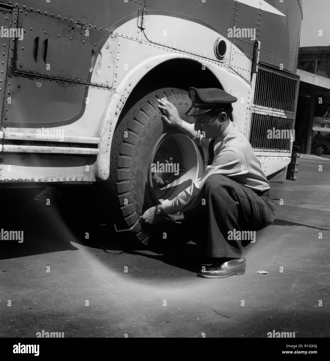 Columbus, Ohio. Randy Pribble, un chauffeur de bus pour la Pennsylvanie Greyhound Lines, Inc., contrôle des pneus sur un bus par les coups avant de le sortir sur une exécution. Puisqu'il y a deux pneus à l'arrière, le son est le meilleur moyen de savoir si l'un d'eux est plat. Septembre 1943 Banque D'Images