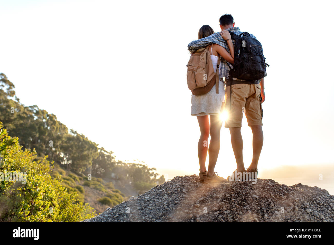 Vue arrière du sac à dos de randonnée avec couple debout ensemble sur une  colline bénéficiant de magnifiques paysages. L'homme et de la femme à  l'extérieur sur la randonnée debout sur une