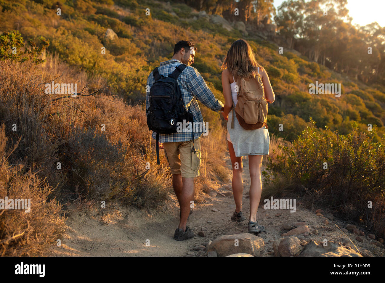 Couple de randonneurs marche sur la colline. L'homme et la femme avec sac à dos en descendant la piste de montagne. Banque D'Images