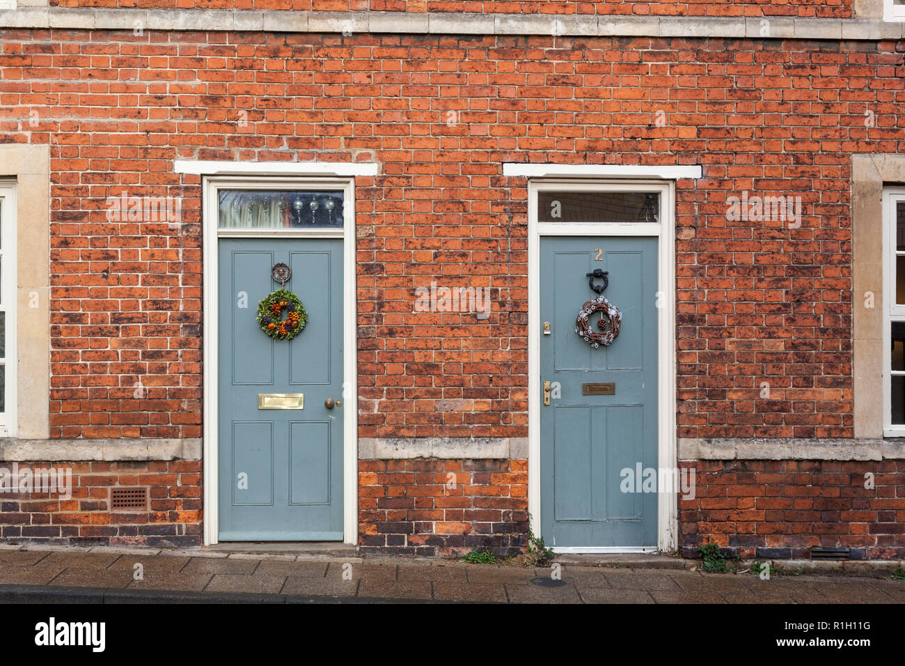 Deux vieilles portes dans une brique exposée de maisons les deux ont des couronnes de Noël ci-joint. Banque D'Images