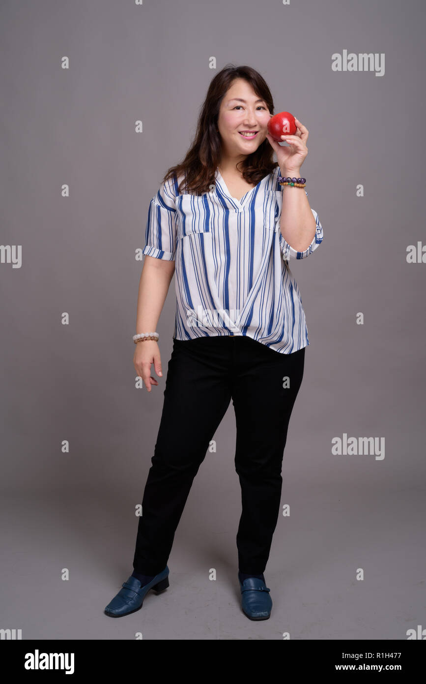 Full Length portrait of Japanese businesswoman holding apple Banque D'Images