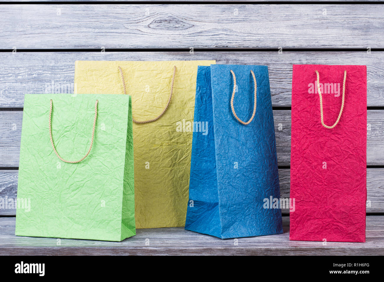 Collection de sacs colorés sur fond de bois. Banque D'Images