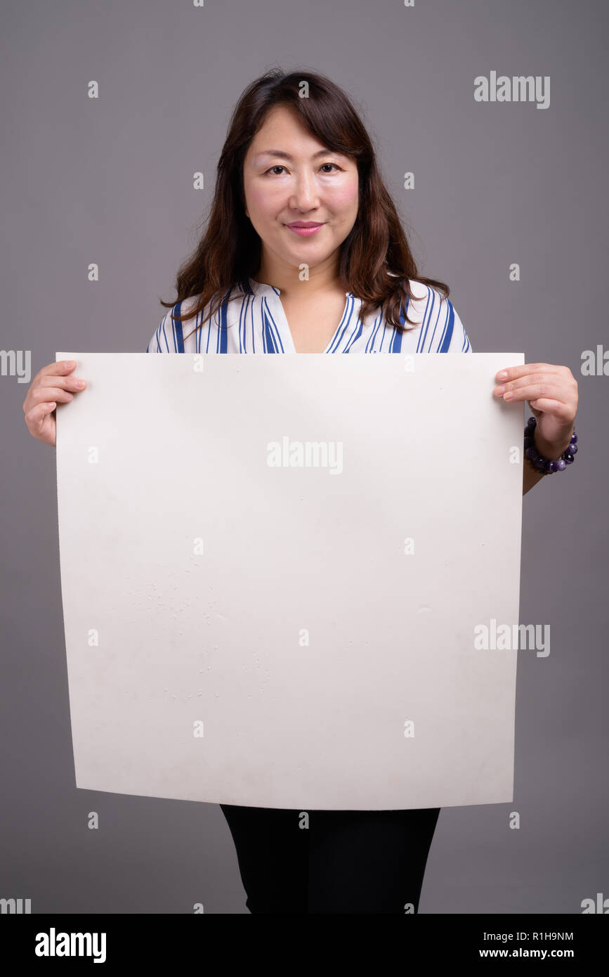 Japonaise mature businesswoman holding empty white copy space Banque D'Images