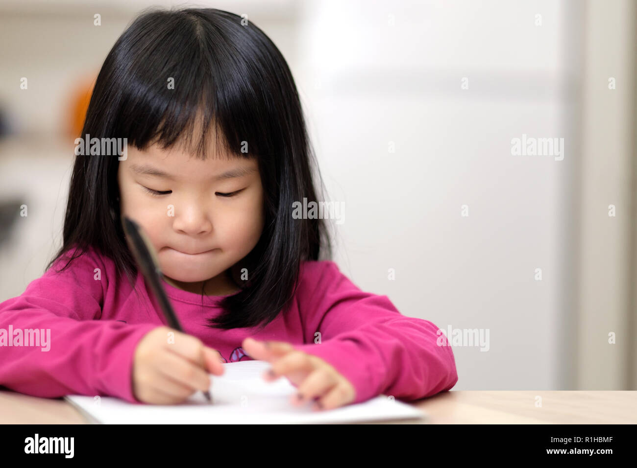 Jeune fille asiatique peu l'apprentissage de l'écriture Banque D'Images