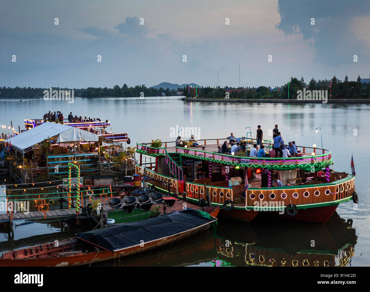 Restaurant touristique côté rivière bateaux au coucher du soleil dans le centre ville de kampot Cambodge Banque D'Images