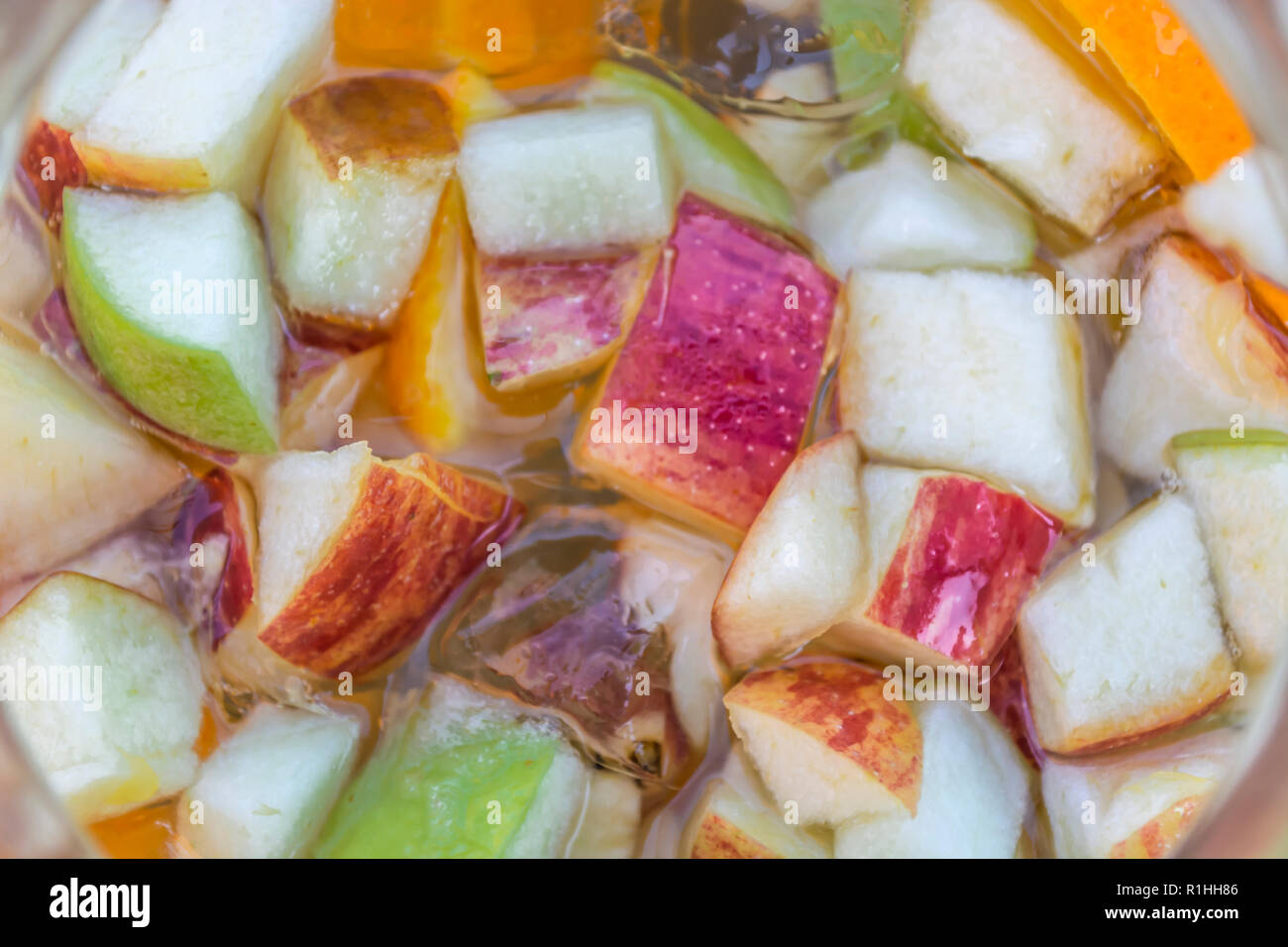 Vue détaillée à la fabrication des fruits, pomme, orange et concombre, le champagne sangria verre... Banque D'Images