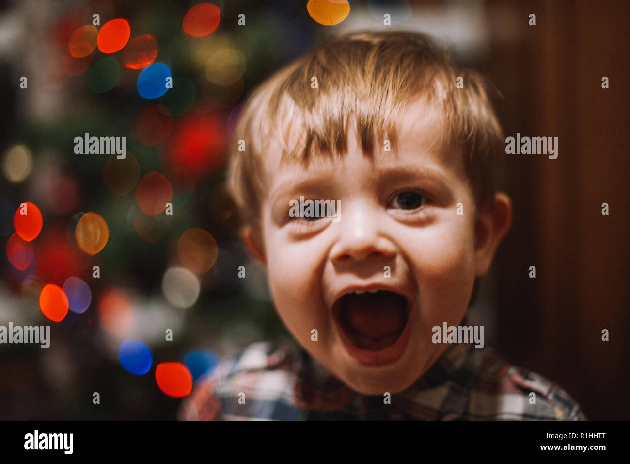 Cheerful baby boy avec bouche ouverte jouant à la maison durant les vacances de Noël Banque D'Images