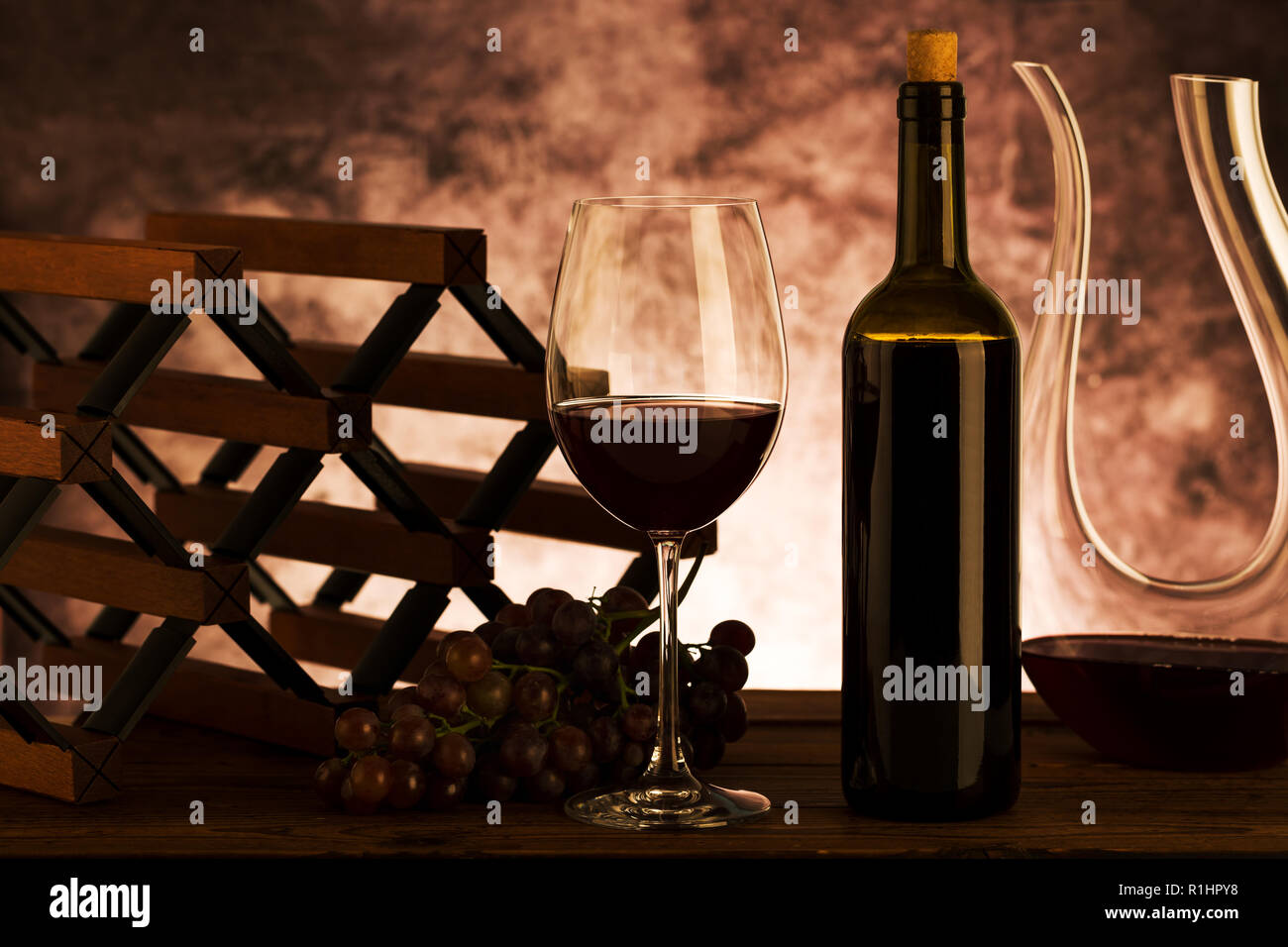 Vin rouge. Verre de vin rouge, les raisins et la carafe sur fond de bois. Banque D'Images