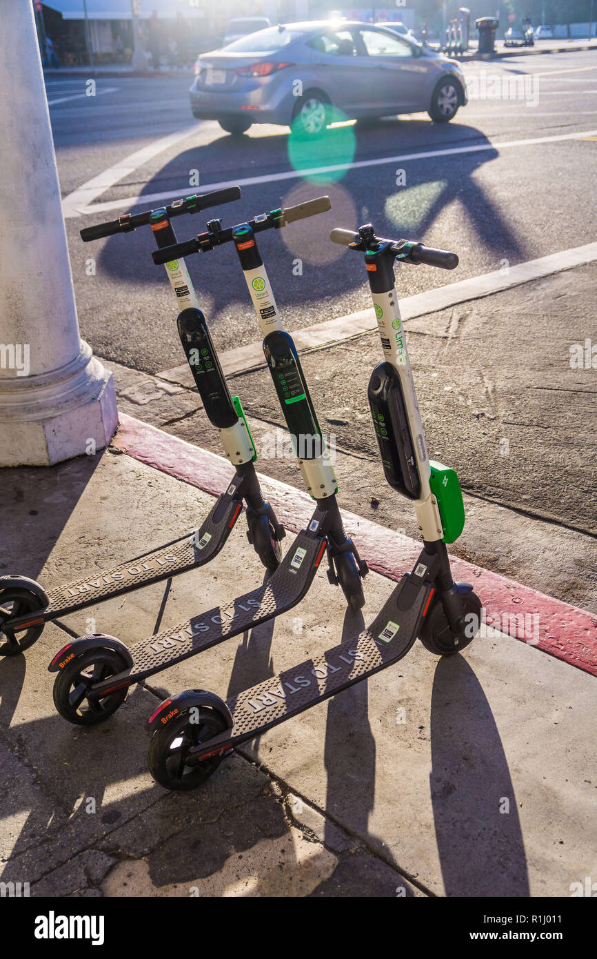 Un groupe de la chaux des scooters électriques en attente pour les cavaliers à Venice Beach Banque D'Images