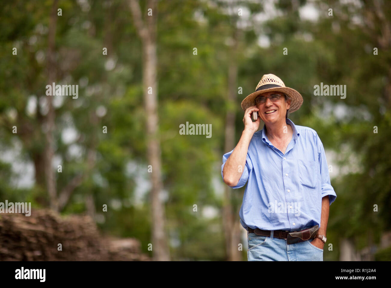 Man talking on cell phone marche sur route de campagne. Banque D'Images