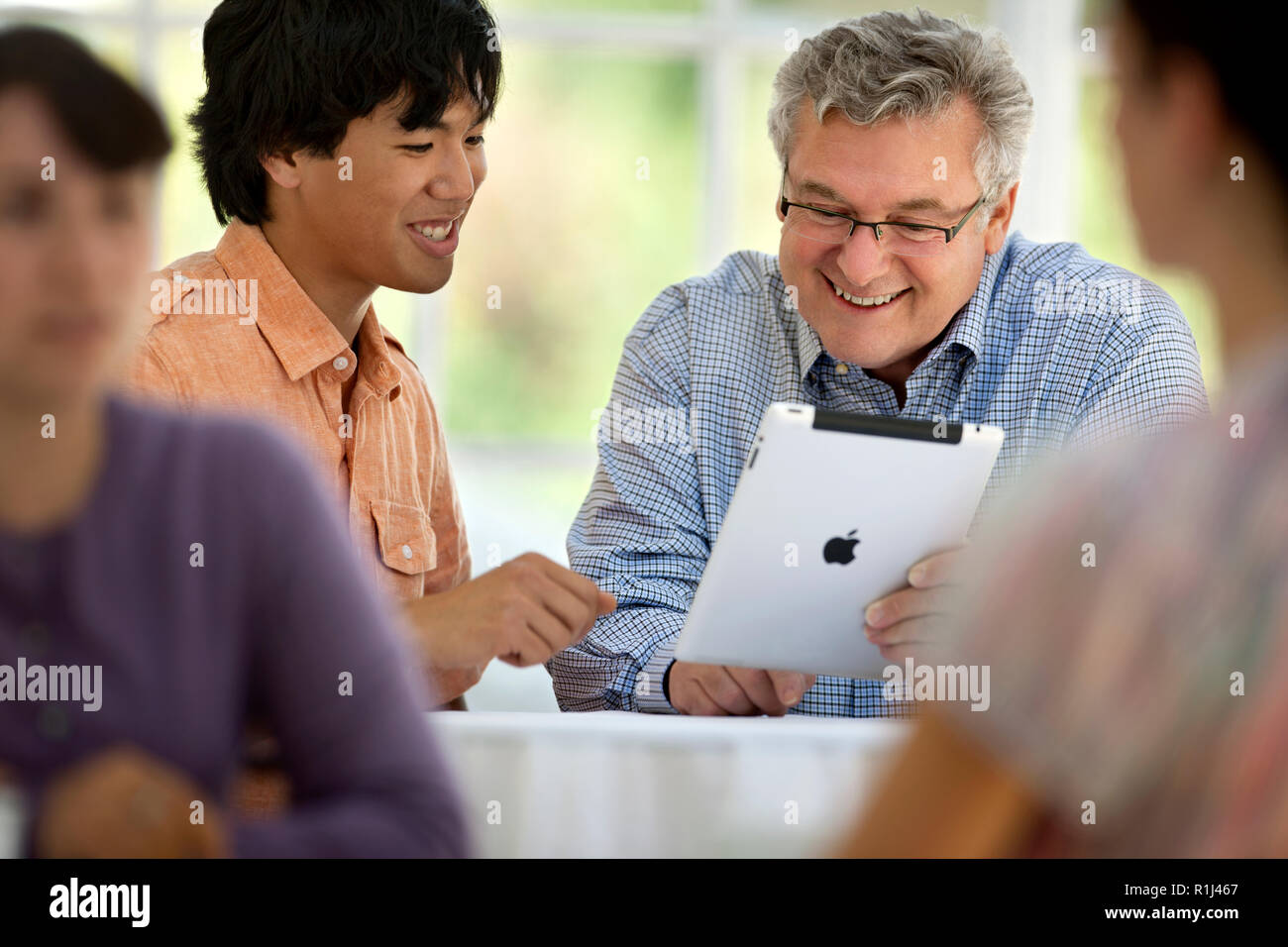 Un jeune homme et un homme mûr à la tablette numérique à un. Banque D'Images