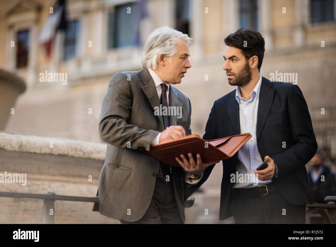 Mature businessman a une rencontre fortuite avec un jeune collègue, alors qu'ils sont dans la ville. Banque D'Images
