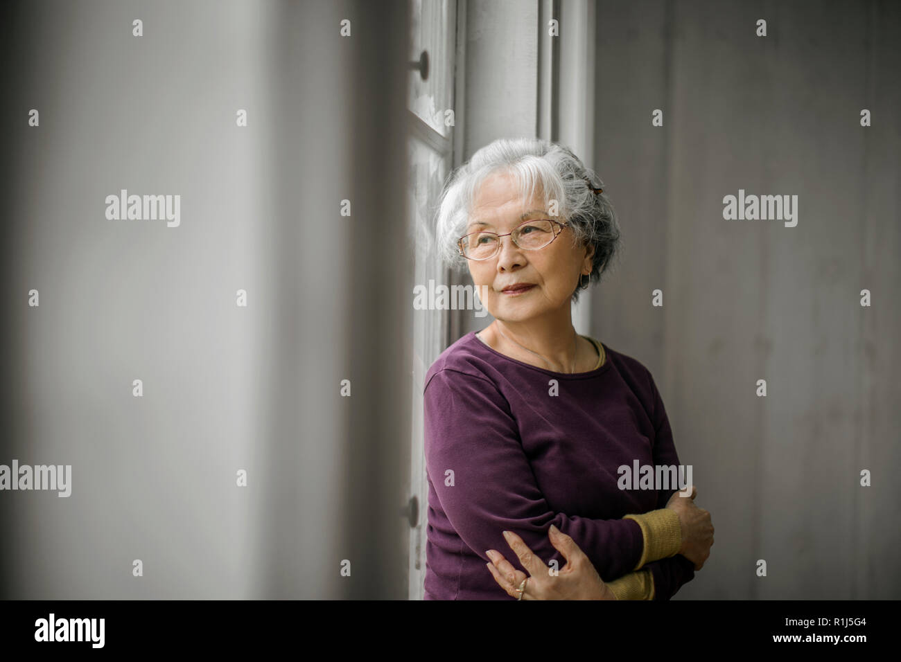 Portrait of a smiling woman regarder par la fenêtre. Banque D'Images