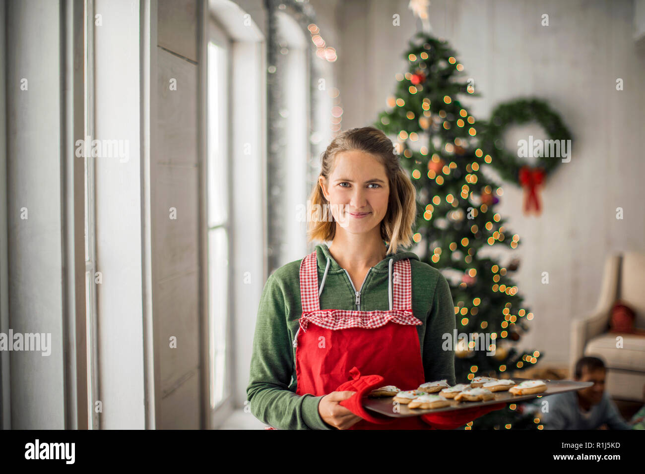 Portrait of a smiling woman holding a tray de biscuits de Noël. Banque D'Images