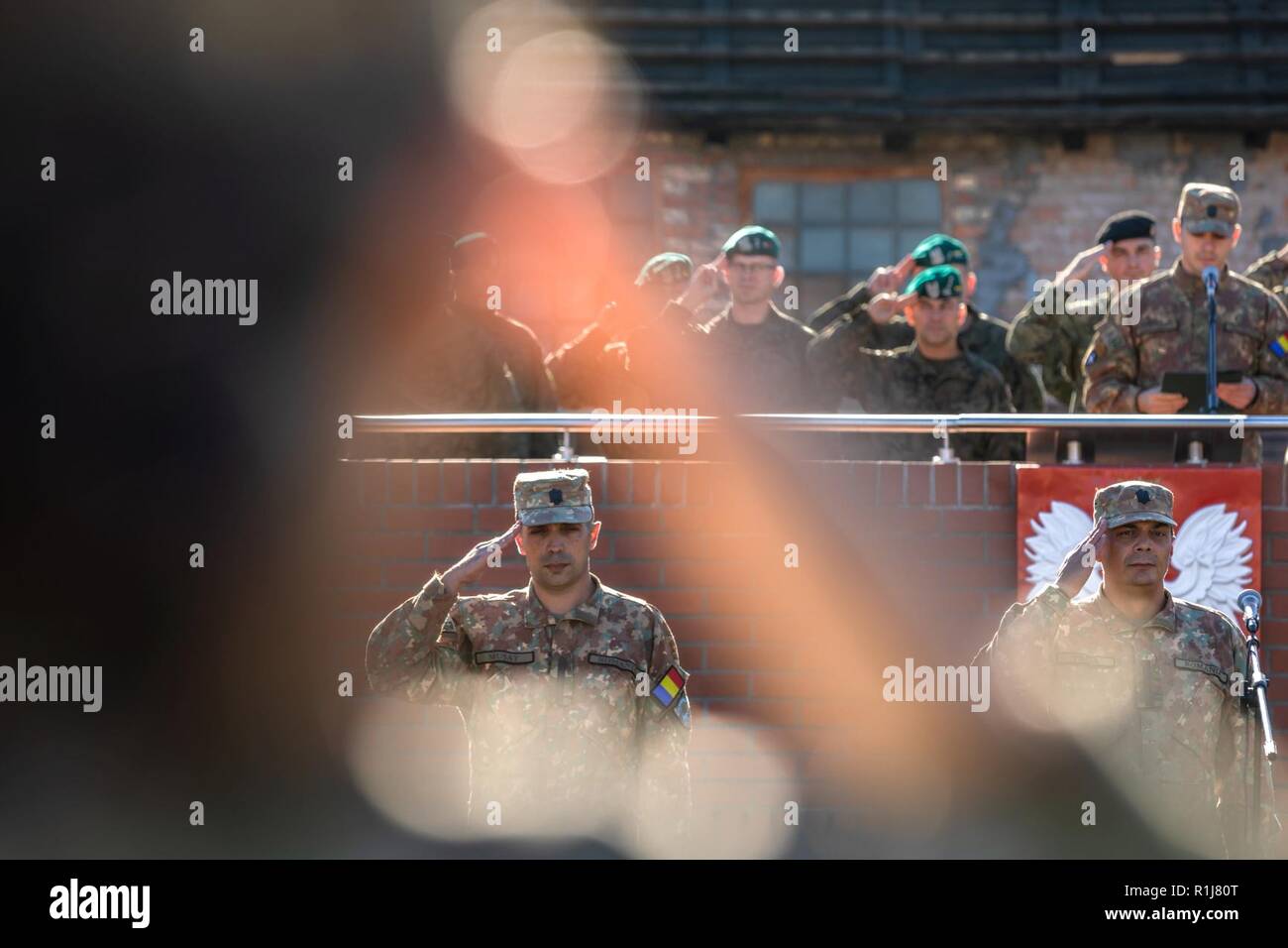 Les commandants entrant et sortant de la Pologne du groupement tactique de défense aérienne roumaine saluer leurs troupes pendant une cérémonie de transfert d'autorité à Bemowo Piskie Domaine de formation, le 4 octobre. Le Bleu des Scorpions, dirigée par le Major Octavian Musat (à gauche), sont remplacées par les chauves-souris noire, dirigée par le major Julian Stoica (droite). La Pologne est un groupe de combat, unique coalition multinationale d'États-Unis, Royaume-Uni, croate, et de soldats roumains qui servent avec la 15e Brigade mécanisée polonaise comme un moyen de défense et de dissuasion de l'OTAN à l'appui de l'amélioration de l'avant la Présence. ( Banque D'Images