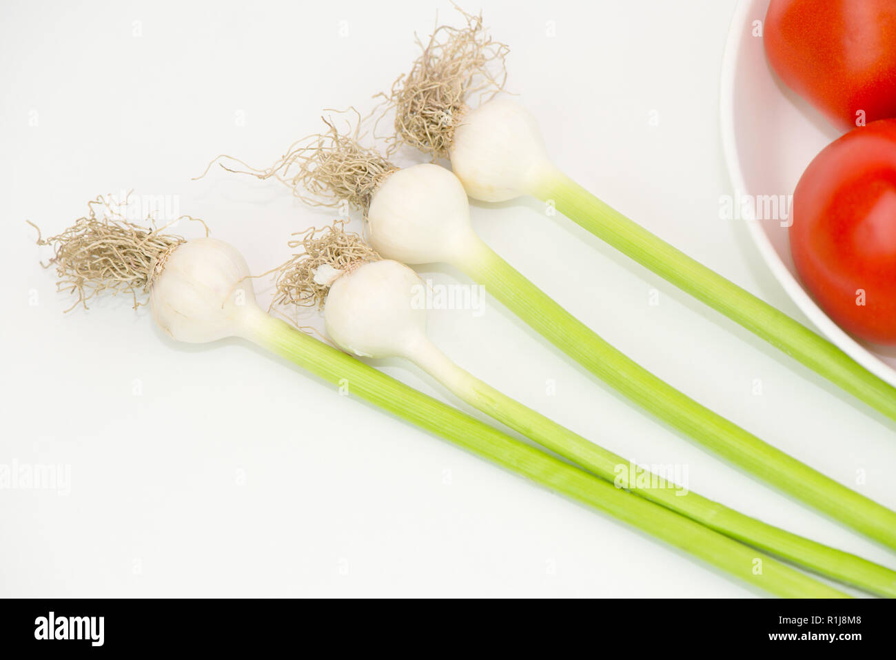L'ail et les tomates vertes sur fond blanc Banque D'Images