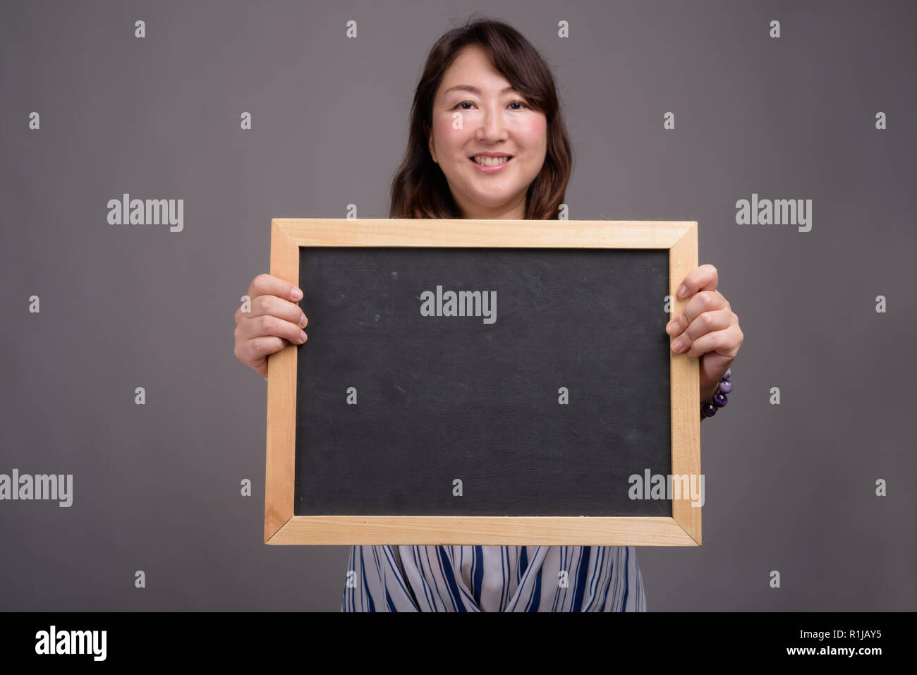 Asian businesswoman holding blackboard with copy space Banque D'Images