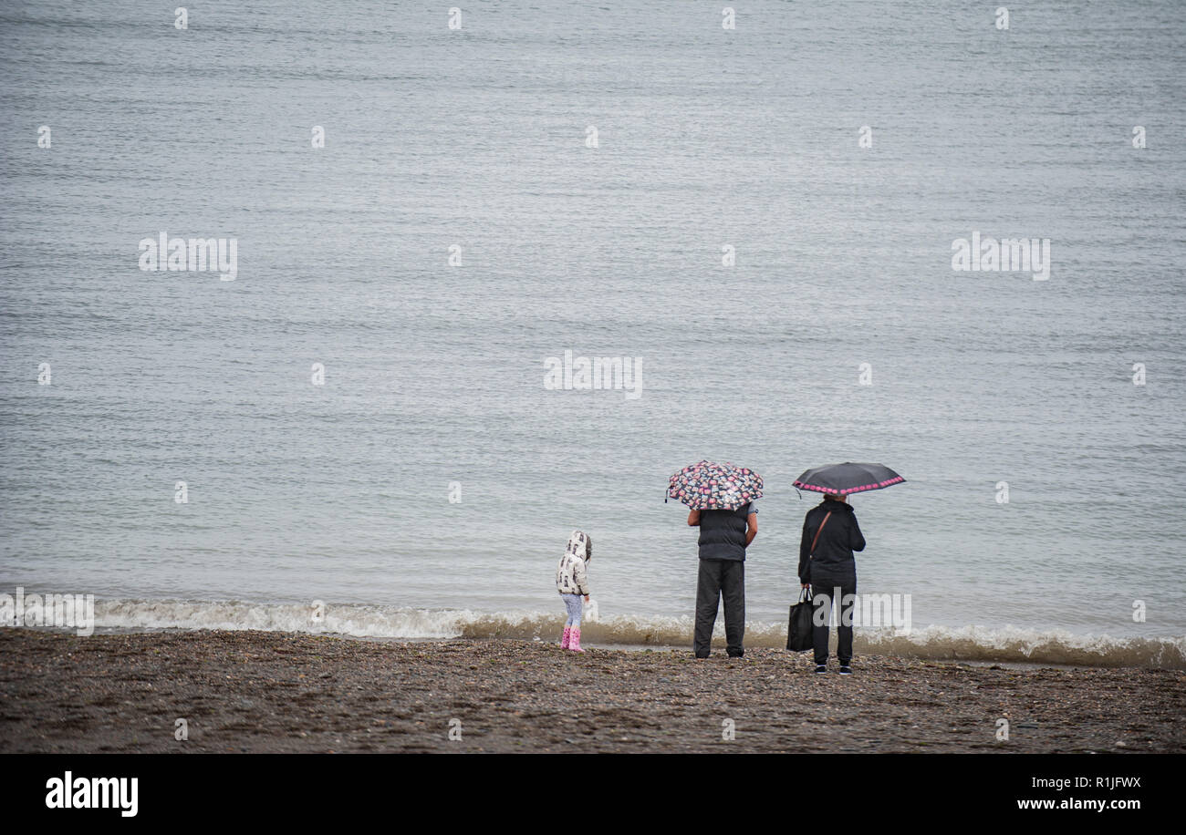 Les gens qui vaquent à leur vie quotidienne sous la pluie. Banque D'Images