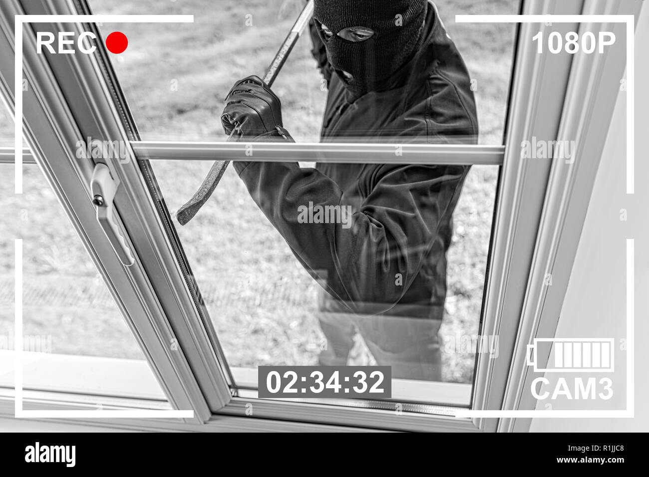 Vue de CCTV cambrioleur en rupture d'accueil à travers la vitre avec pince Banque D'Images
