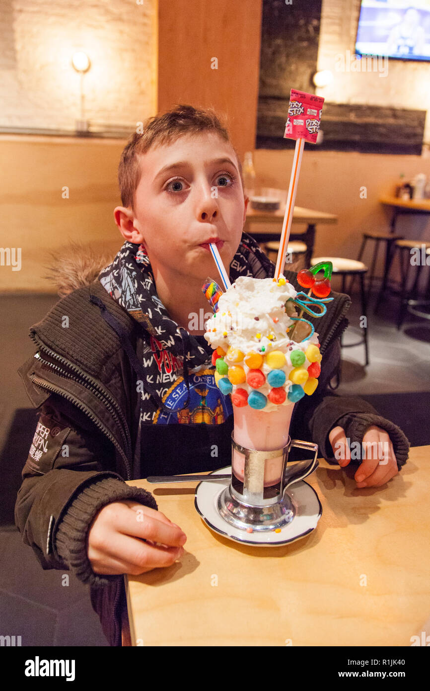 Un garçon de neuf ans avec une alimentation sure Black cherry Crazy Shake, Shake à robinet noir, Ludlow Street, Lower East Side, New York, États-Unis d'Amérique. Banque D'Images