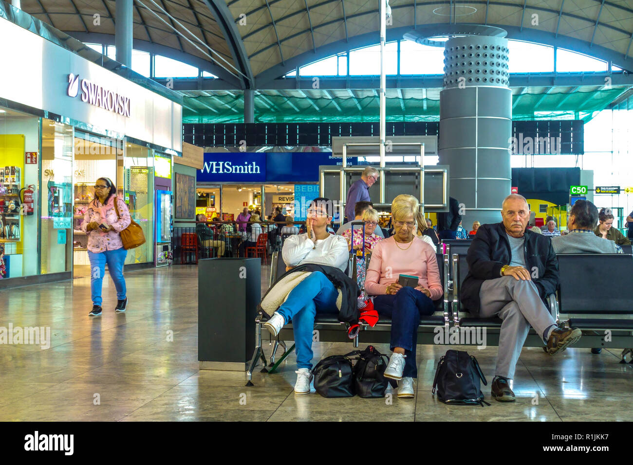L'aéroport d'Alicante en Espagne, les gens se reposant dans le hall des départs Banque D'Images