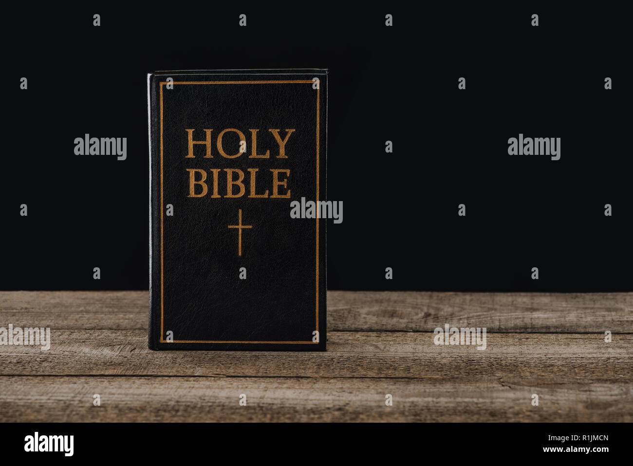 Gros plan de la sainte bible debout sur une table en bois isolé sur black Banque D'Images