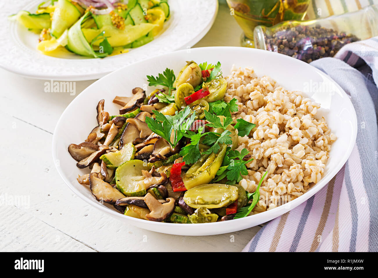 Menu de régime. Repas végétarien sain - les champignons shiitake, courgette et le porridge d'avoine sur la cuvette. La nourriture végétalienne. Banque D'Images