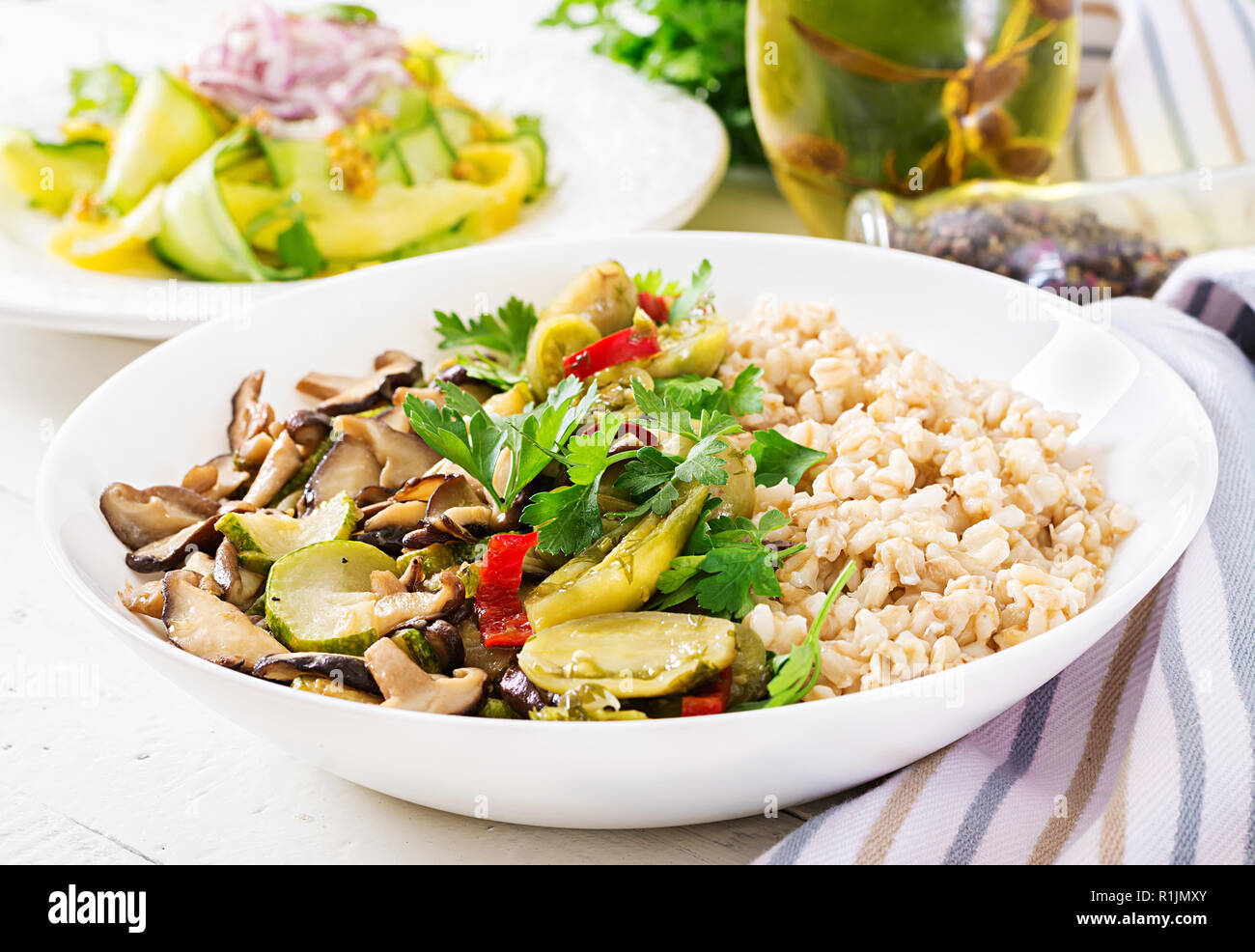 Menu de régime. Repas végétarien sain - les champignons shiitake, courgette et le porridge d'avoine sur la cuvette. La nourriture végétalienne. Banque D'Images