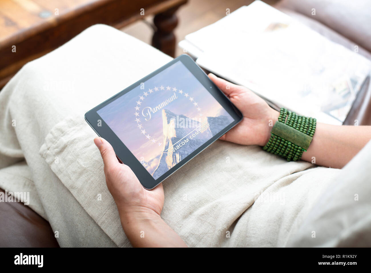 Woman holding ipad streaming Netflix film intérieur sur canapé Banque D'Images