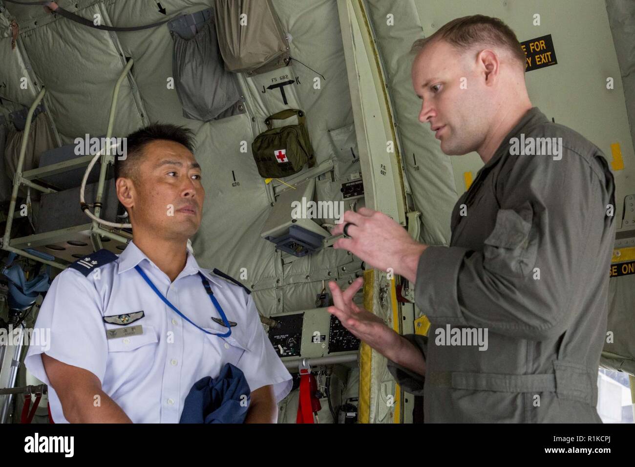 Le capitaine des Marines, un pilote Wesselink Nolan avec ravitaillement en vol de l'Escadron de transport maritime (VMGR) 152, montre un officier japonais Exchange Program (JOEP) participant un KC-130J Super Hercules à Iwakuni Marine Corps Air Station, Japon, le 11 octobre 2018. La confiance, la cohésion JOEP augmente, et le partenariat entre les pilotes américains et japonais tout en apprenant sur différents appareils. Banque D'Images