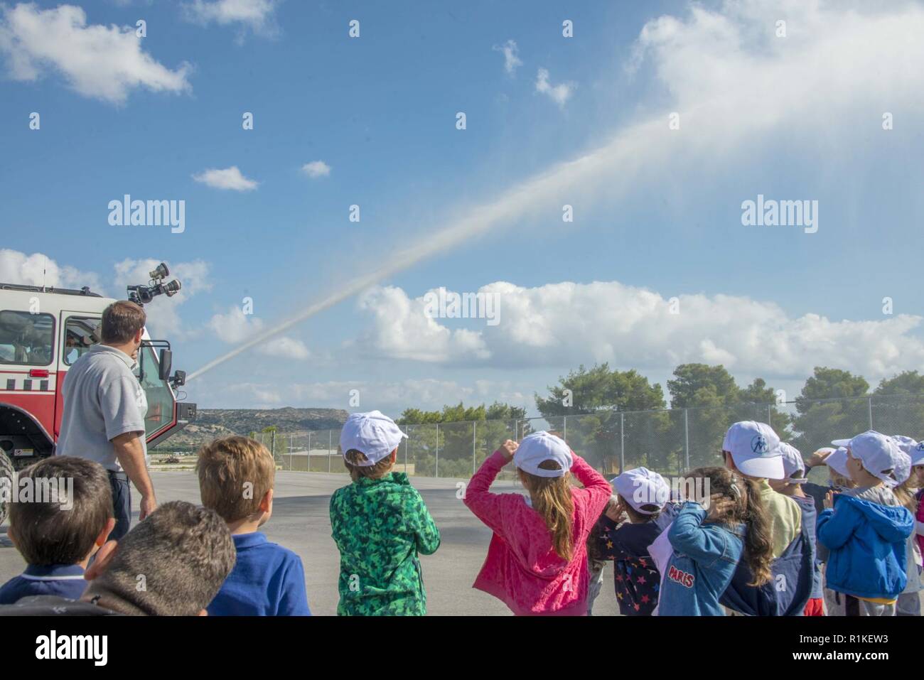 La base navale américaine de la baie de Souda, Grèce (oct. 9, 2018) un camion de pompiers de la Marine américaine affecté à la base navale américaine (NSA) Baie de Souda, la Grèce l'incendie et d'urgence de l'eau des pulvérisations au cours d'une manifestation d'étudiants de l'école privée Mavromataki durant la Semaine de la prévention des incendies à bord de l'installation le 9 octobre 2018. La NSA Souda Bay Fire & Emergency Services Department a fait équipe avec la National Fire Protection Association (NFPA) pour promouvoir cette année, la campagne de la Semaine de prévention des incendies, "l'aspect. Écouter. En savoir. Être au courant. Le feu peut se produire n'importe où, qui s'efforce de sensibiliser le public abou Banque D'Images