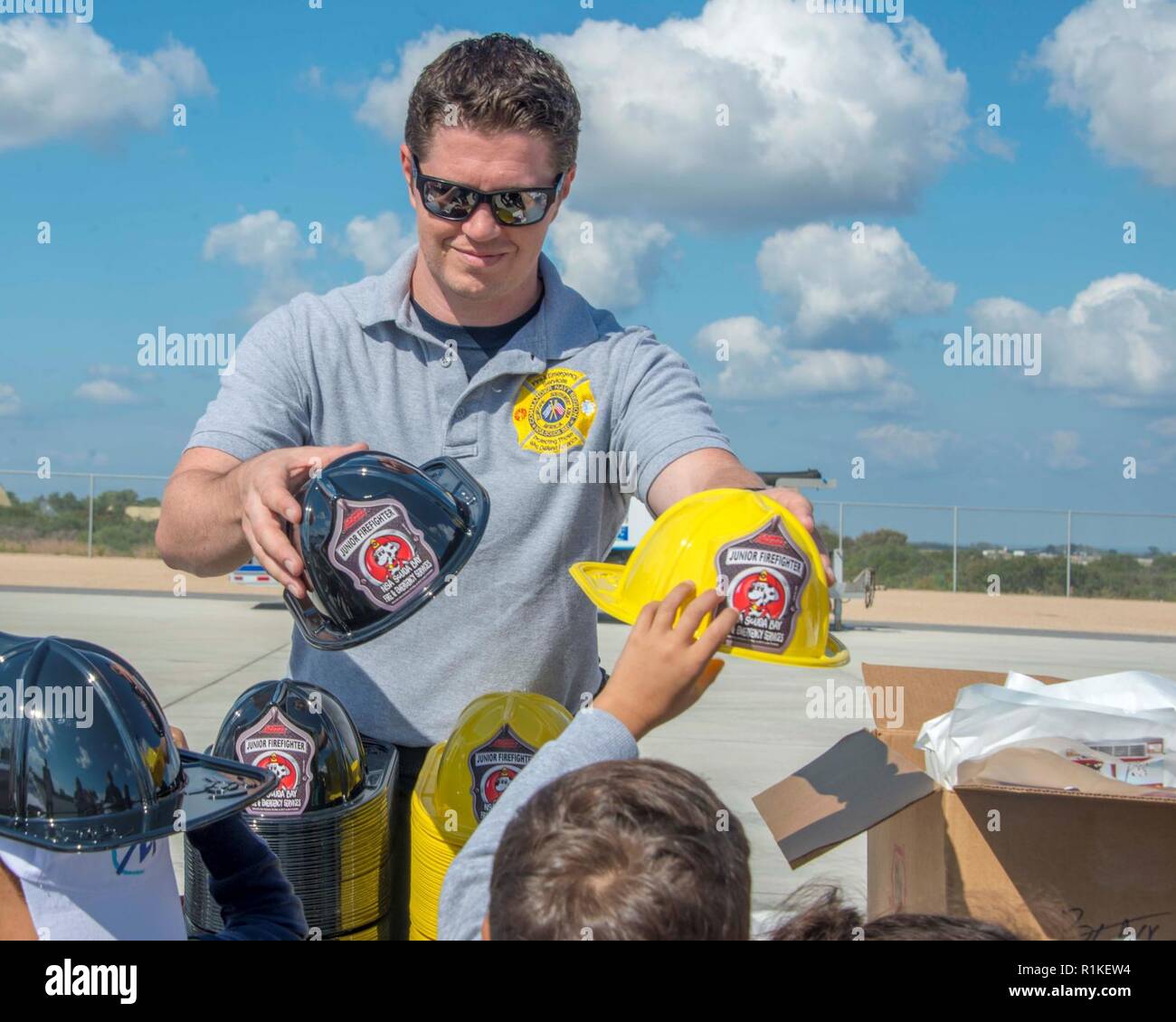 La base navale américaine de la baie de Souda, Grèce (oct. 9, 2018) Ken Doan, un pompier affecté à la base navale américaine (NSA) Baie de Souda, Grèce, passe des chapeaux de pompier junior pour les étudiants de l'école privée Mavromataki durant la Semaine de la prévention des incendies à bord de l'installation le 9 octobre 2018. La NSA Souda Bay Fire & Emergency Services Department a fait équipe avec la National Fire Protection Association (NFPA) pour promouvoir cette année, la campagne de la Semaine de prévention des incendies, "l'aspect. Écouter. En savoir. Être au courant. Le feu peut se produire n'importe où, qui s'efforce de sensibiliser le public au sujet des moyens essentiels de base mais Banque D'Images
