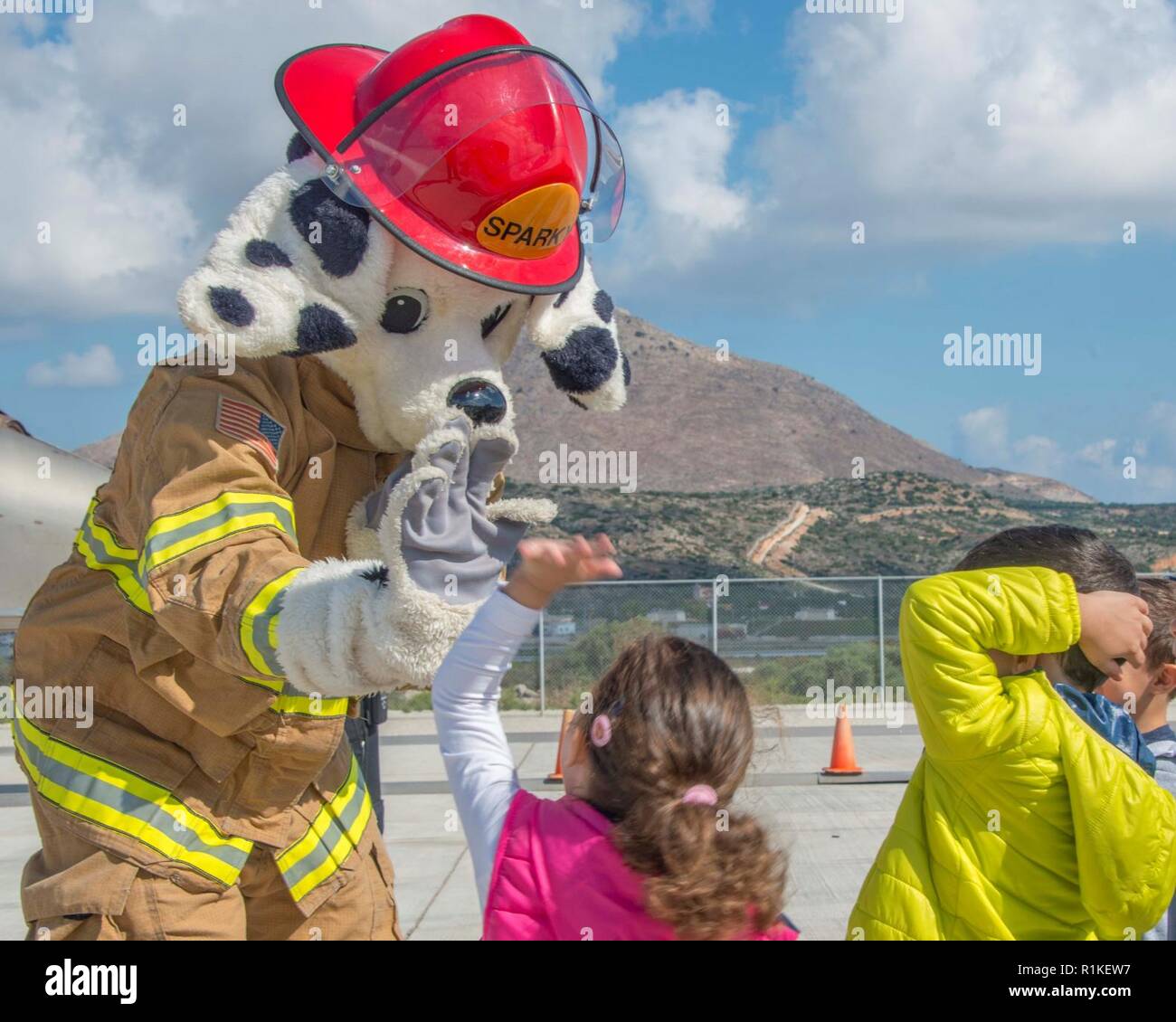 La base navale américaine de la baie de Souda, Grèce (oct. 9, 2018), Sparky la National Fire Prevention Association (NFPA) mascot, donne un haut-cinq à un étudiant de l'école privée Mavromataki durant la Semaine de la prévention des incendies à bord de l'installation le 9 octobre 2018. La NSA Souda Bay Fire & Emergency Services Department a fait équipe avec la National Fire Protection Association (NFPA) pour promouvoir cette année, la campagne de la Semaine de prévention des incendies, "l'aspect. Écouter. En savoir. Être au courant. Le feu peut se produire n'importe où, qui s'efforce de sensibiliser le public au sujet de base, mais essentiel des moyens de s'échapper rapidement et en toute sécurité une maison Banque D'Images