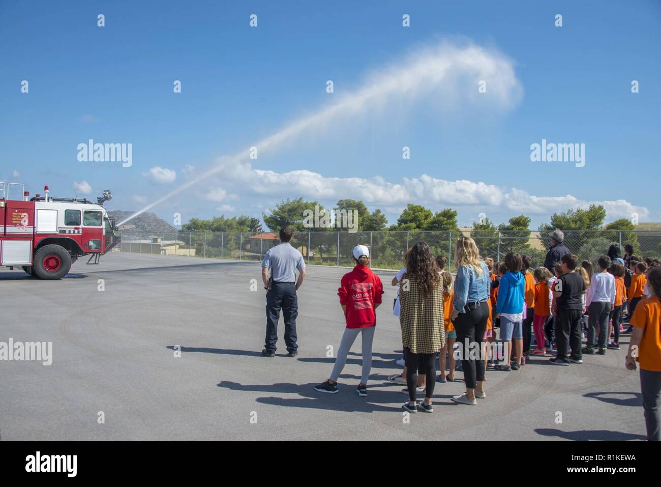 La base navale américaine de la baie de Souda, Grèce (oct. 9, 2018) un camion de pompiers de la Marine américaine affecté à la base navale américaine (NSA) Baie de Souda, la Grèce, l'incendie et d'urgence, les pulvérisations d'eau pendant une manifestation pour les étudiants de l'école privée pendant la Theodoropoulos Semaine de prévention des incendies à bord de l'installation le 9 octobre 2018. La NSA Souda Bay Fire & Emergency Services Department a fait équipe avec la National Fire Protection Association (NFPA) pour promouvoir cette année, la campagne de la Semaine de prévention des incendies, "l'aspect. Écouter. En savoir. Être au courant. Le feu peut se produire n'importe où, qui s'efforce de sensibiliser le public Banque D'Images
