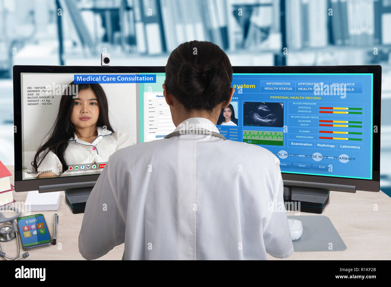 Femme médecin travaillant avec deux ordinateurs pour la consultation du patient à distance et la recherche d'information sur la santé de son système de dossier médical. Banque D'Images