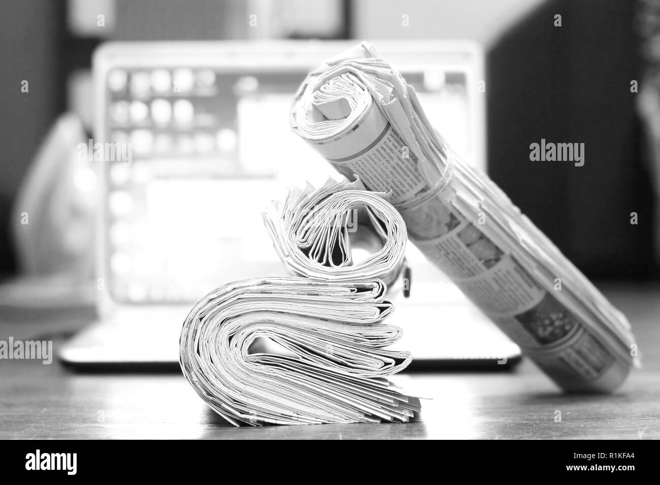 Journaux et l'ordinateur. Plié et roulé des journaux et des magazines sur la table en face de l'ordinateur portable ouvert. Concept pour l'information, différentes sources d'informations Banque D'Images
