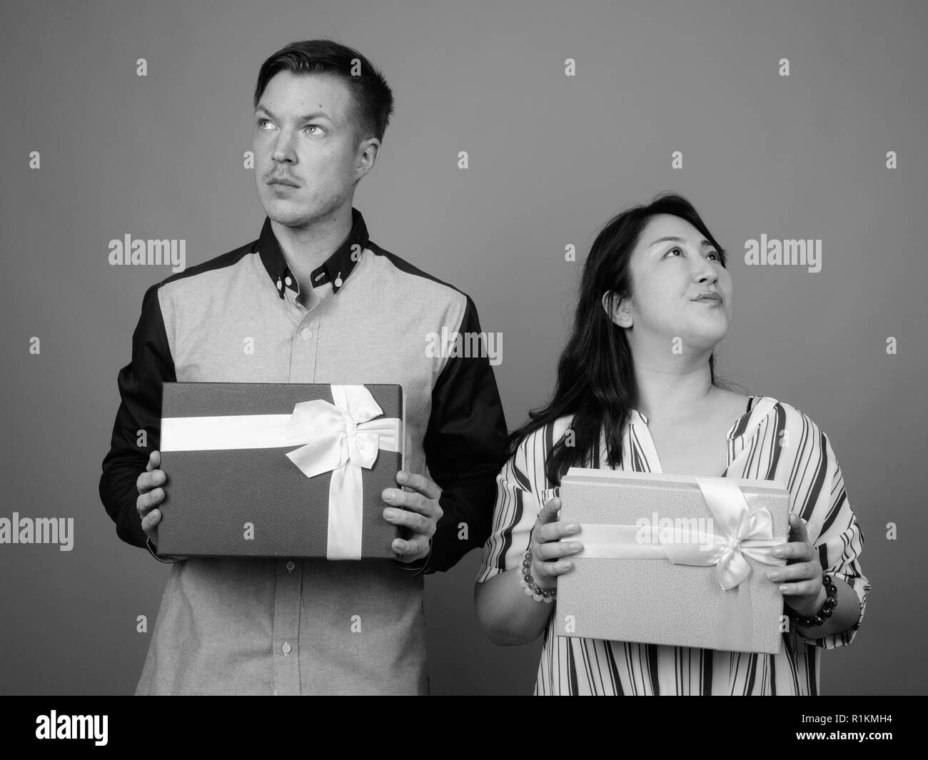 Businessman et mature Asian businesswoman holding gift box Banque D'Images