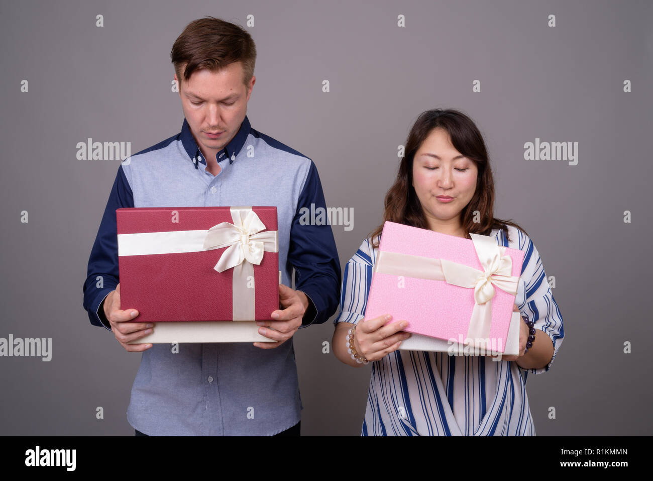 Businessman et mature Asian businesswoman holding gift box Banque D'Images