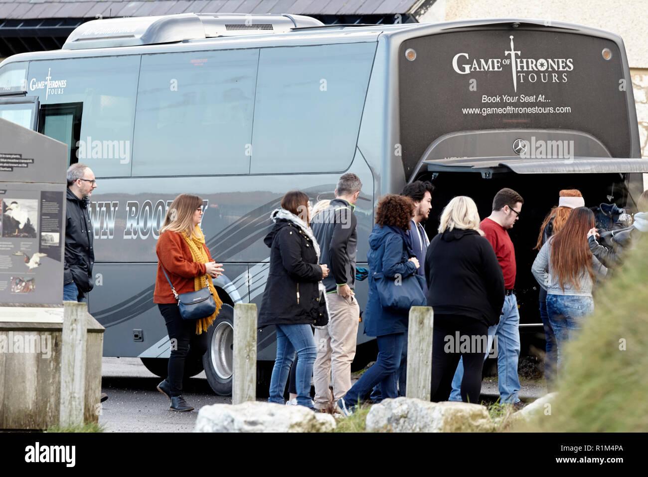 Les touristes sur un jeu des trônes coach tour guidé à Ballintoy sur le Nord de la côte nord d'Irlande Banque D'Images