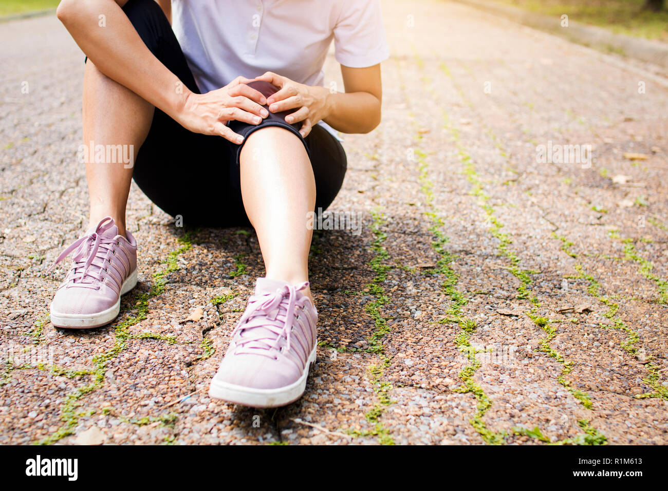 Sport femme, runner a une douleur au genou ou de blessure à la jambe après le travail et running in park Banque D'Images