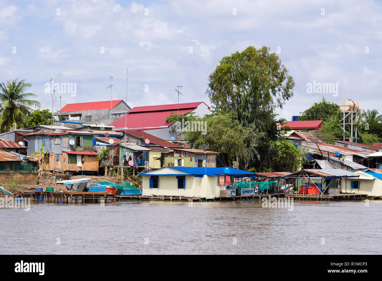 Taudis typiques de tôle ondulée maisons sur pilotis au village de pêcheurs le long de la rivière du Mékong. Le Cambodge, en Asie du sud-est Banque D'Images