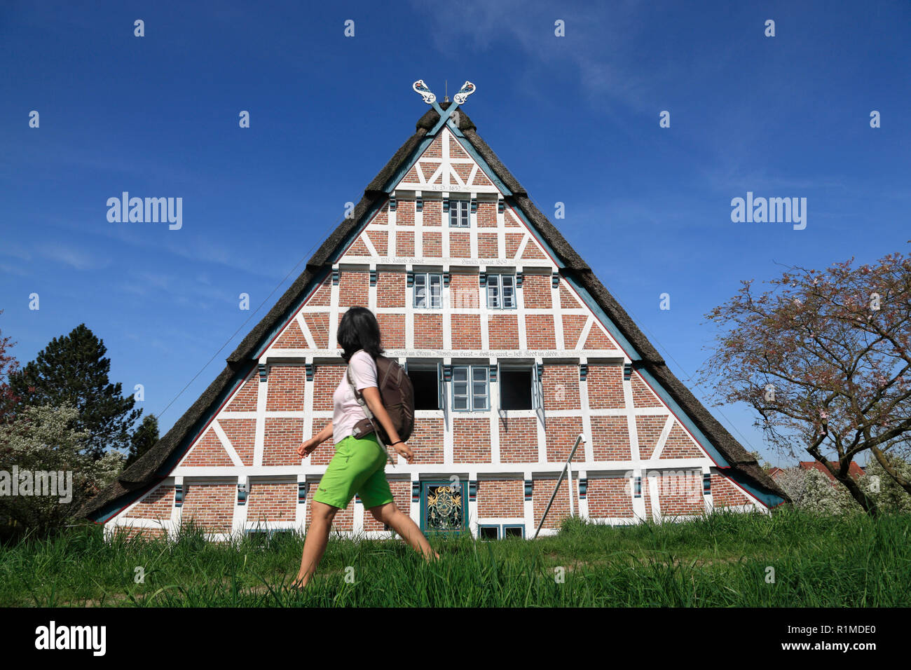Randonneur en face d'une ancienne ferme à Este-Dyke, Jork-Koenigreich, Altes Land, Basse-Saxe, Allemagne, Europe Banque D'Images