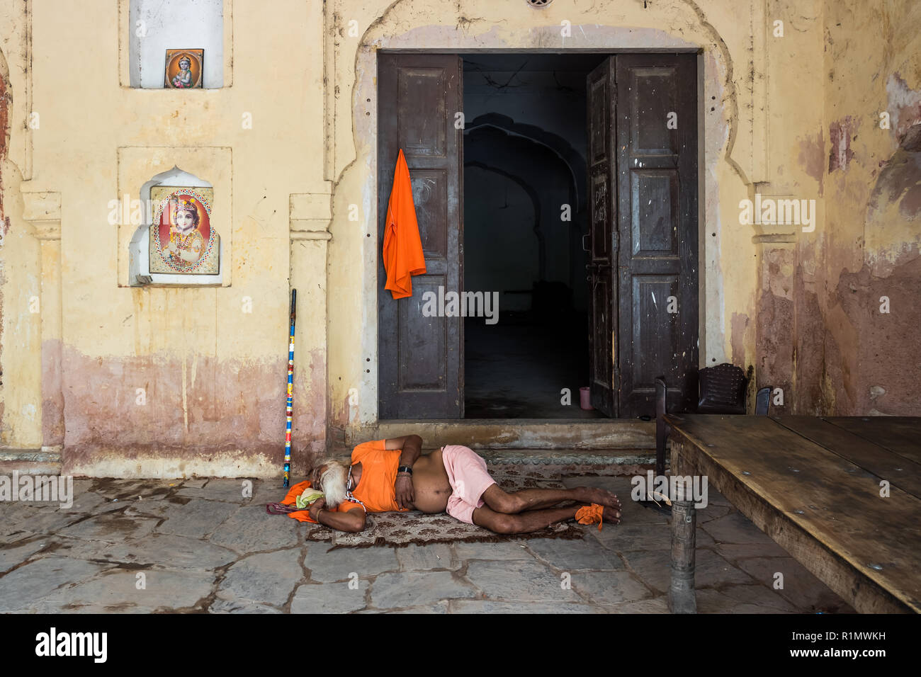 Sadhu reposant à midi en face de la porte d'entrée de l'immeuble. Jaipur L'Inde Juin 2018 Banque D'Images