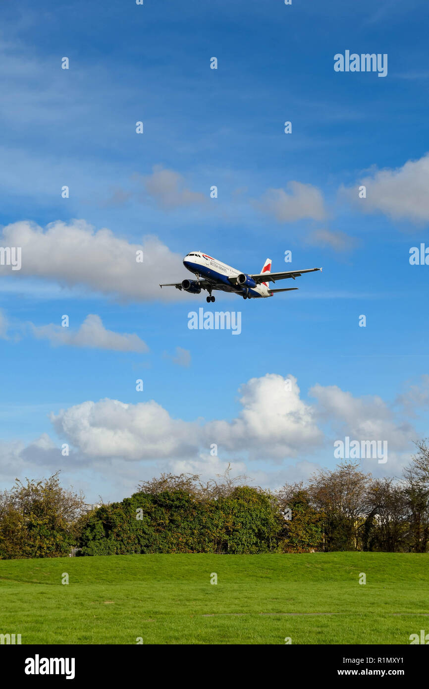 Londres, ANGLETERRE - NOVEMBRE 2018 : grand angle de visualisation d'un British Airways Airbus A320 court-courriers à réaction passant au-dessus des champs sur son approche finale sur terre à Banque D'Images