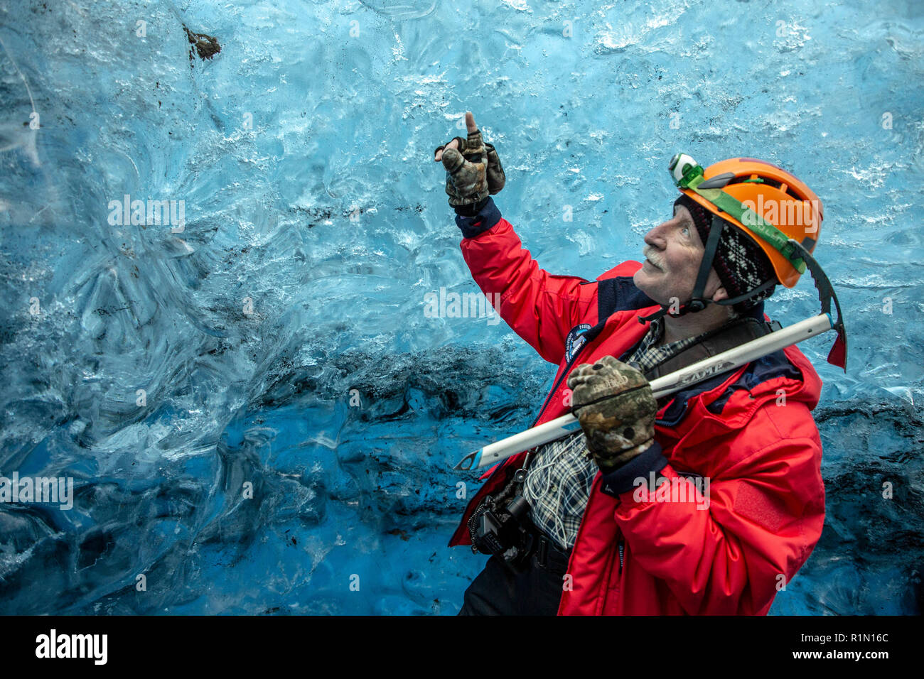 L'homme avec un pic de glace dans une grotte de glace en Islande Banque D'Images