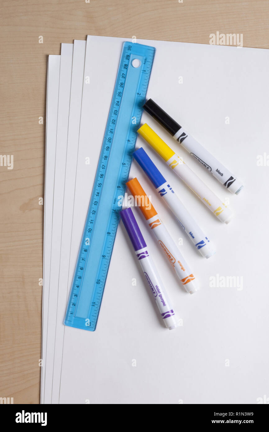 L'école et des fournitures artistiques y compris des marqueurs de couleur, une règle, bleu et blanc tag board sur un bureau Banque D'Images
